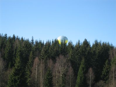 Ballongen kommer över skogskanten.